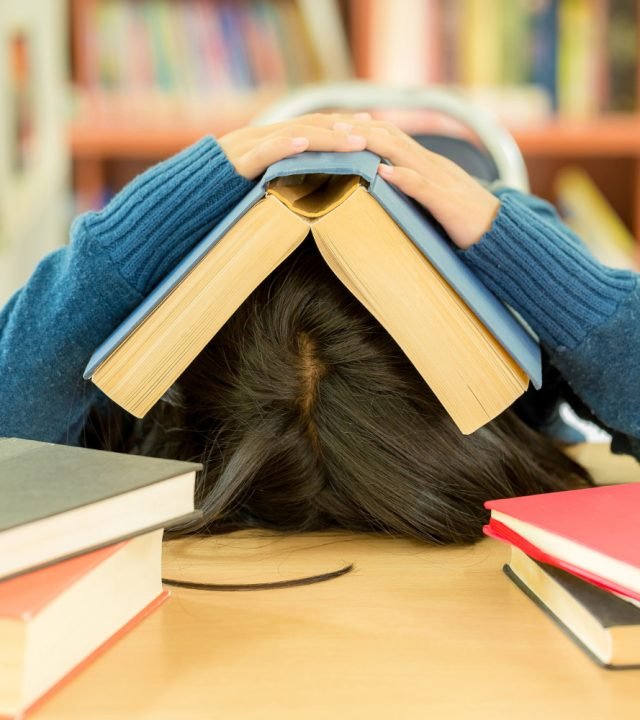 portrait-clever-student-with-open-book-reading-it-college-library